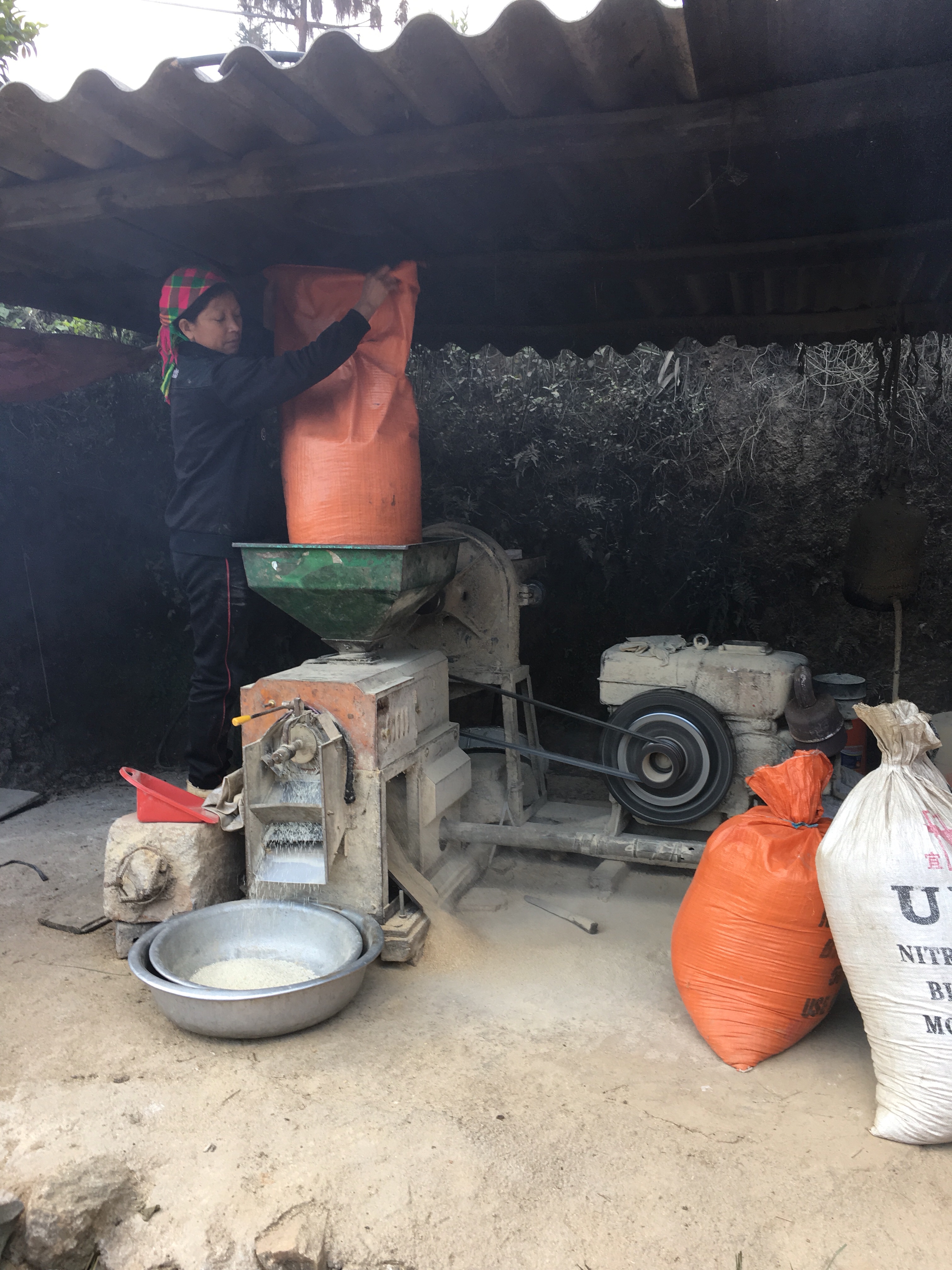 Woman hard at rock. Down the street, men hanging out. 